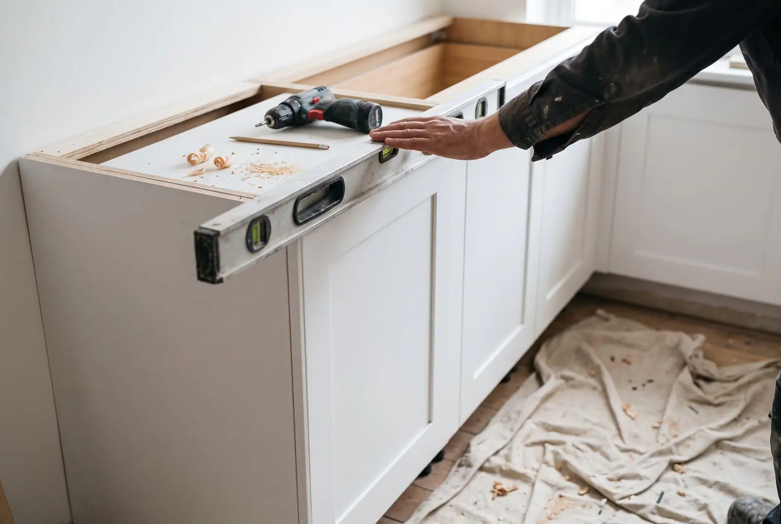A spirit level on a newly fitted white kitchen cabinet