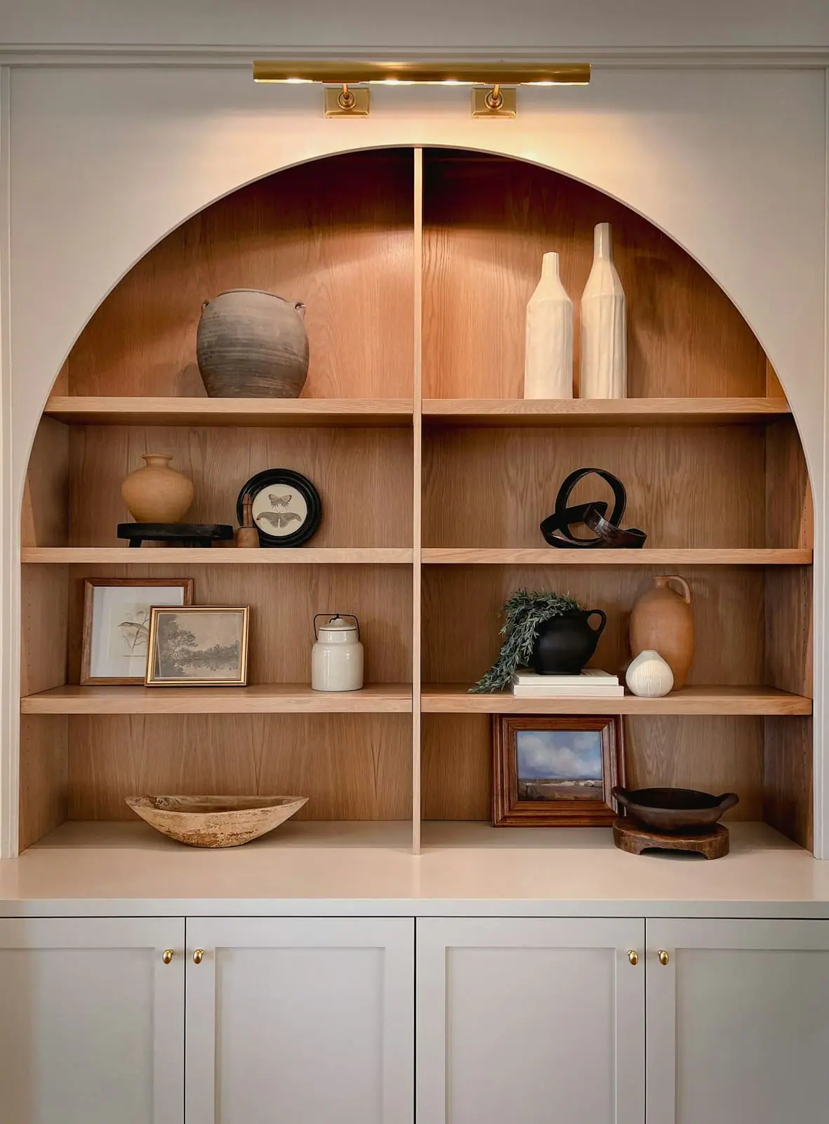 Arched oak shelving built into an alcove